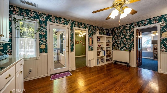 24083 Cresta Dr, Crestline, CA 92325 - unfurnished room with wallpapered walls, dark wood finished floors, a wainscoted wall, and ceiling fan
