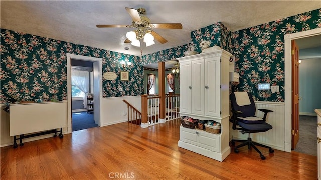24083 Cresta Dr, Crestline, CA 92325 - entrance foyer featuring wallpapered walls, a wainscoted wall, wood finished floors, and a ceiling fan