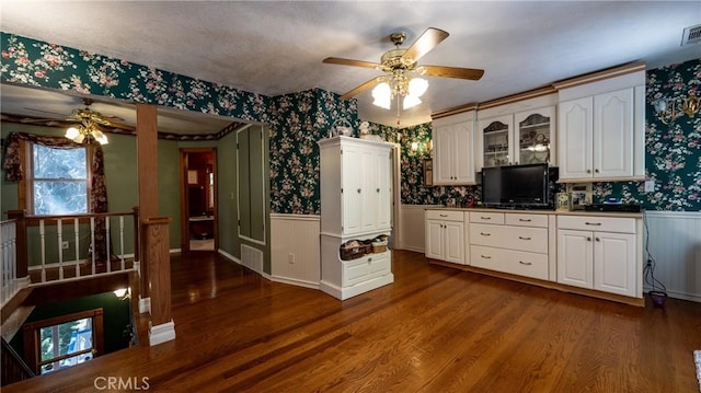 24083 Cresta Dr, Crestline, CA 92325 - kitchen featuring wallpapered walls, a ceiling fan, a wainscoted wall, dark wood finished floors, and white cabinets