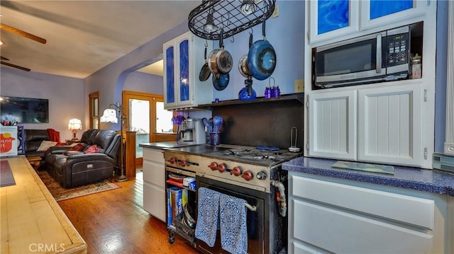 24083 Cresta Dr, Crestline, CA 92325 - kitchen featuring appliances with stainless steel finishes, wood finished floors, a ceiling fan, dark countertops, and arched walkways