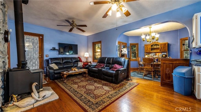 24083 Cresta Dr, Crestline, CA 92325 - living area with arched walkways, a chandelier, a wood stove, and a ceiling fan