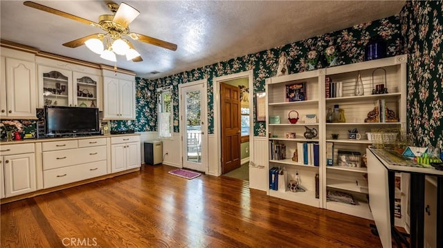 24083 Cresta Dr, Crestline, CA 92325 - kitchen with wallpapered walls, dark wood finished floors, ceiling fan, glass insert cabinets, and white cabinets