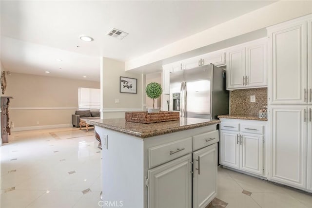 15521 Sandra Ln, Sylmar, CA 91342 - kitchen featuring stainless steel fridge, open floor plan, tasteful backsplash, light stone counters, and a center island