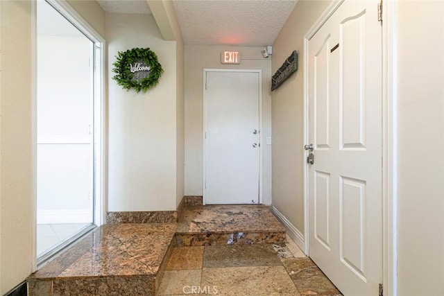 15521 Sandra Ln, Sylmar, CA 91342 - doorway featuring a textured ceiling and stone finish floors