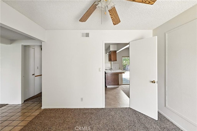 457 Brian Ct, Merced, CA 95348 - spare room featuring ceiling fan, light tile patterned floors, a textured ceiling, and light colored carpet