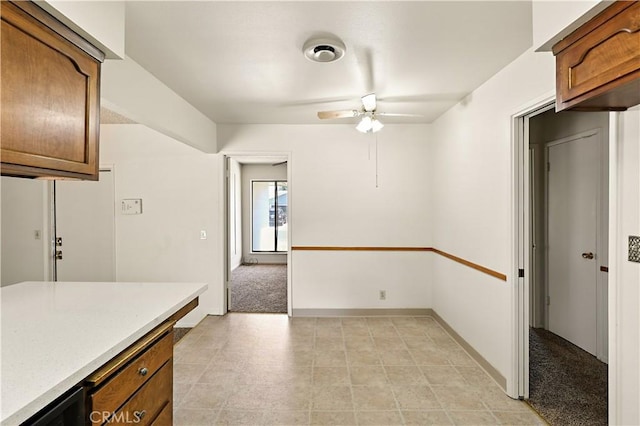 457 Brian Ct, Merced, CA 95348 - kitchen featuring a ceiling fan, brown cabinetry, light countertops, and light tile patterned floors