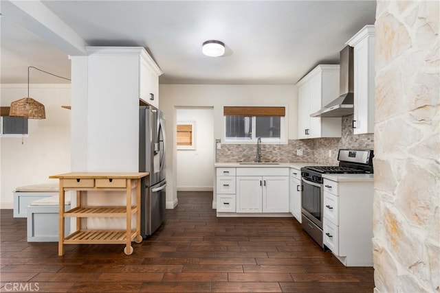 14137 Viburnum Dr, Whittier, CA 90604 - kitchen featuring appliances with stainless steel finishes, wall chimney range hood, light countertops, dark wood-style flooring, and white cabinetry