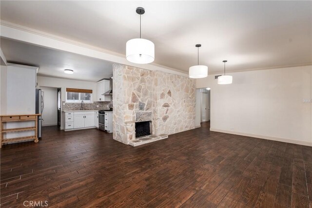 14137 Viburnum Dr, Whittier, CA 90604 - unfurnished living room featuring dark wood-style flooring, crown molding, and a stone fireplace