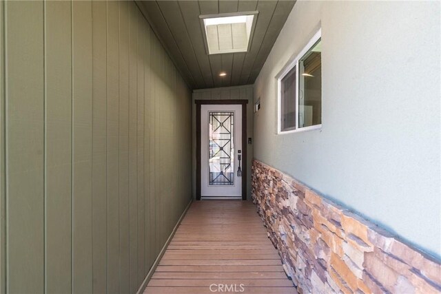 14137 Viburnum Dr, Whittier, CA 90604 - doorway to outside featuring light wood-style floors and wood walls