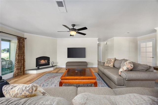 28201 Stallion Springs Dr, Tehachapi, CA 93561 - living area with wood finished floors, crown molding, ceiling fan, and a warm lit fireplace