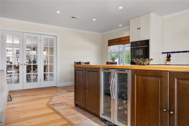 28201 Stallion Springs Dr, Tehachapi, CA 93561 - kitchen with beverage cooler, french doors, oven, crown molding, and light wood-style floors