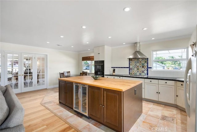 28201 Stallion Springs Dr, Tehachapi, CA 93561 - kitchen with beverage cooler, wall chimney exhaust hood, wood counters, french doors, and decorative backsplash