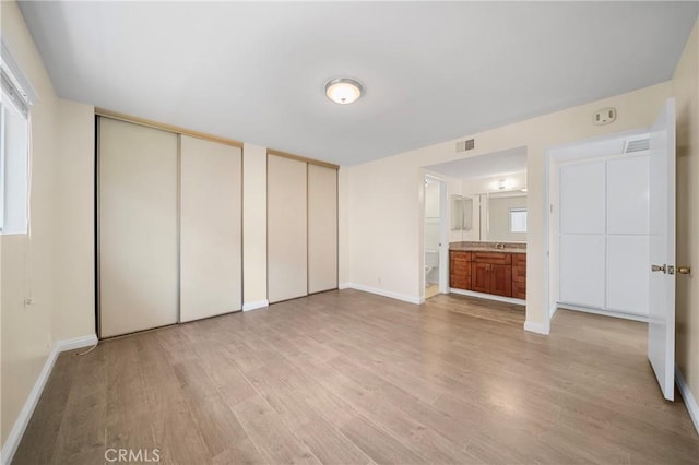 1524 Acacia Unit 5, Alhambra, CA 91801 - unfurnished bedroom with multiple closets, light wood finished floors, and ensuite bathroom