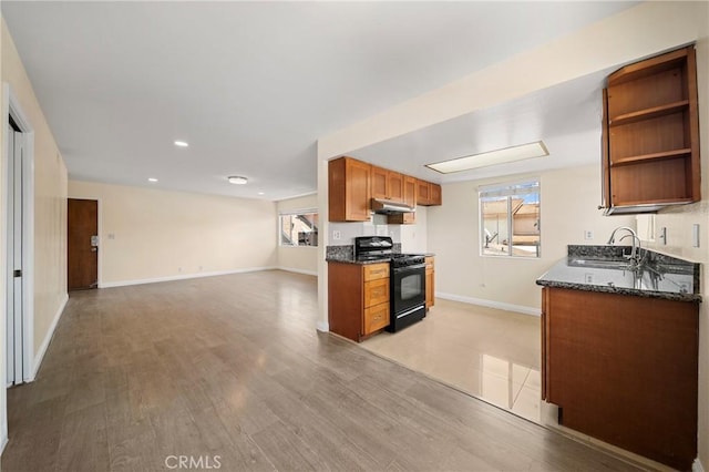 1524 Acacia Unit 5, Alhambra, CA 91801 - kitchen with black range with gas cooktop, open floor plan, under cabinet range hood, brown cabinets, and dark stone counters