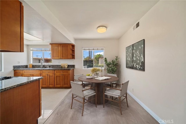 1524 Acacia Unit 5, Alhambra, CA 91801 - kitchen featuring light wood-style floors, brown cabinetry, healthy amount of natural light, and open shelves