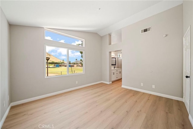 15965 Peach Tree Ln, Fontana, CA 92337 - unfurnished bedroom with vaulted ceiling, light wood-style floors, and connected bathroom