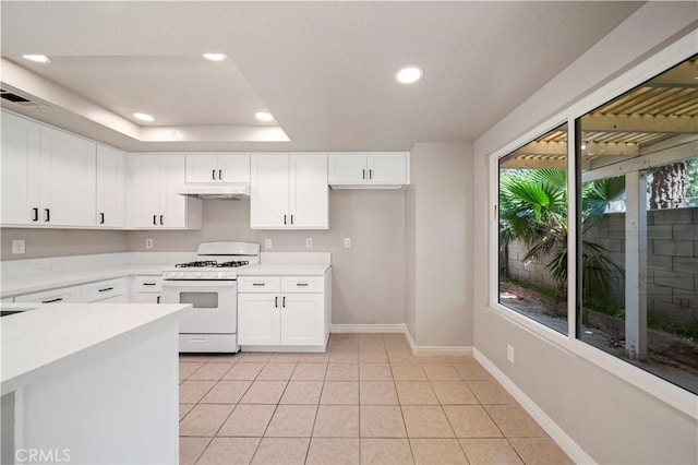 15965 Peach Tree Ln, Fontana, CA 92337 - kitchen featuring white range with gas stovetop, under cabinet range hood, recessed lighting, light countertops, and white cabinetry