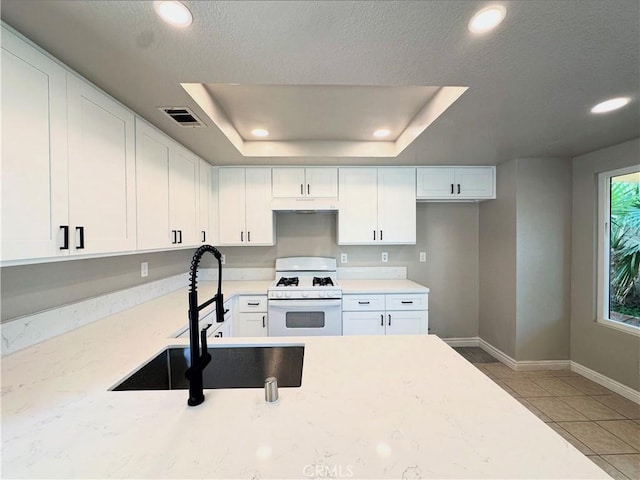 15965 Peach Tree Ln, Fontana, CA 92337 - kitchen featuring gas range gas stove, white cabinets, recessed lighting, a raised ceiling, and under cabinet range hood