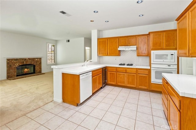 2311 Gillingham Cir, Thousand Oaks, CA 91362 - kitchen with white appliances, under cabinet range hood, light countertops, wine cooler, and light colored carpet