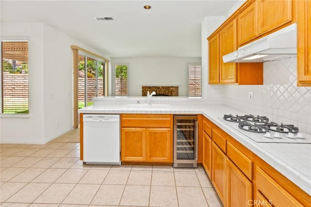 2311 Gillingham Cir, Thousand Oaks, CA 91362 - kitchen featuring white appliances, wine cooler, under cabinet range hood, backsplash, and a peninsula