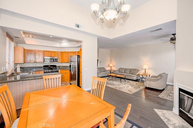 27625 Primrose Ln, Castaic, CA 91384 - dining room with a raised ceiling, a chandelier, wood finished floors, and a ceiling fan