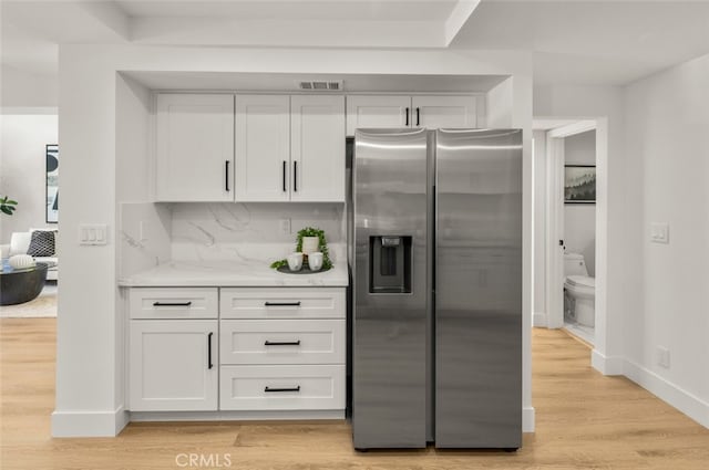 22627 Lakeside Ln, Lake Forest, CA 92630 - kitchen with stainless steel refrigerator with ice dispenser, white cabinetry, light wood-style floors, light stone counters, and backsplash