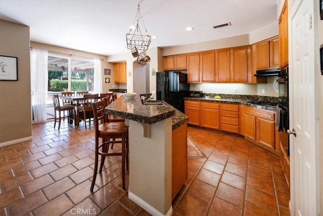 42365 Westar Ct, Murrieta, CA 92562 - kitchen with black appliances, under cabinet range hood, recessed lighting, a chandelier, and a breakfast bar