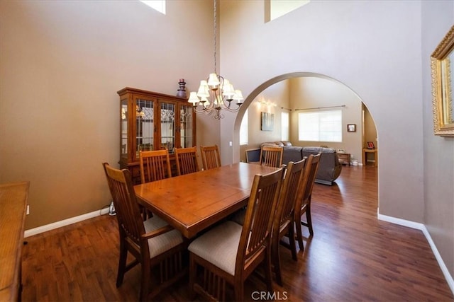 42365 Westar Ct, Murrieta, CA 92562 - dining room with arched walkways, dark wood-type flooring, a high ceiling, and a chandelier