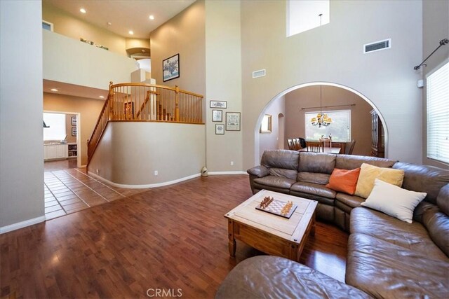 42365 Westar Ct, Murrieta, CA 92562 - living room featuring a towering ceiling, stairs, wood finished floors, arched walkways, and recessed lighting