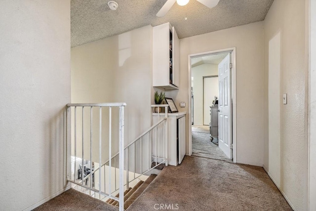 2134 Moonlight Ct, Palmdale, CA 93550 - corridor featuring light colored carpet, an upstairs landing, a textured wall, and a textured ceiling