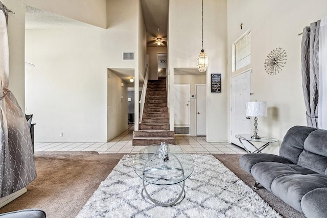 2134 Moonlight Ct, Palmdale, CA 93550 - carpeted living room featuring a high ceiling, stairway, and tile patterned flooring