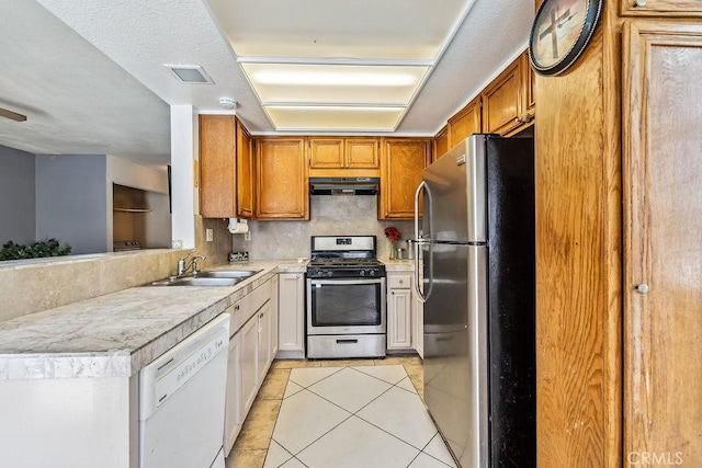 2134 Moonlight Ct, Palmdale, CA 93550 - kitchen featuring stainless steel appliances, under cabinet range hood, light countertops, tasteful backsplash, and light tile patterned flooring