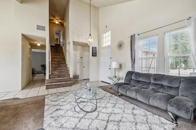 2134 Moonlight Ct, Palmdale, CA 93550 - living room with a high ceiling, tile patterned floors, stairway, and carpet