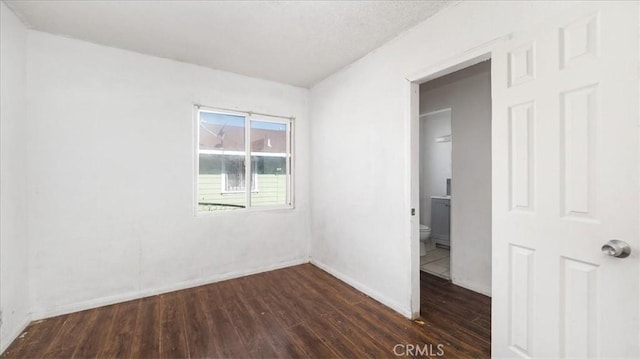 533 E Fredricks St, Barstow, CA 92311 - unfurnished room with dark wood-style floors and baseboards