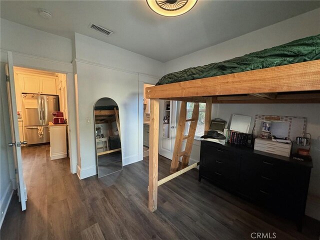 1355 N Gordon St, Pomona, CA 91768 - bedroom featuring freestanding refrigerator, arched walkways, and dark wood-style flooring