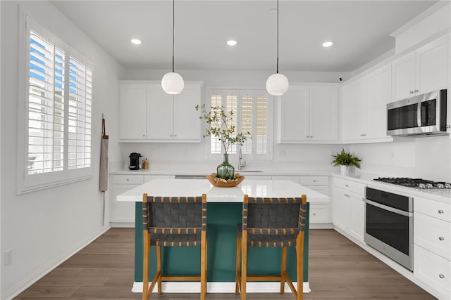 1768 Camellia Ln, Redlands, CA 92374 - kitchen with appliances with stainless steel finishes, a breakfast bar, healthy amount of natural light, white cabinetry, and recessed lighting