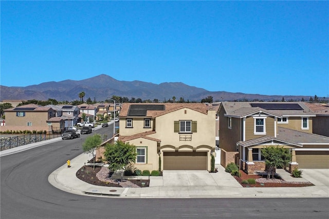1768 Camellia Ln, Redlands, CA 92374 - view of front facade featuring a residential view, concrete driveway, solar panels, stucco siding, and a mountain view