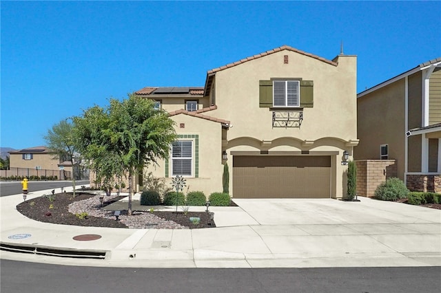 1768 Camellia Ln, Redlands, CA 92374 - mediterranean / spanish house featuring solar panels, stucco siding, an attached garage, concrete driveway, and a tiled roof
