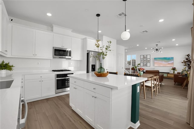 1768 Camellia Ln, Redlands, CA 92374 - kitchen featuring appliances with stainless steel finishes, light wood finished floors, a center island, hanging light fixtures, and recessed lighting
