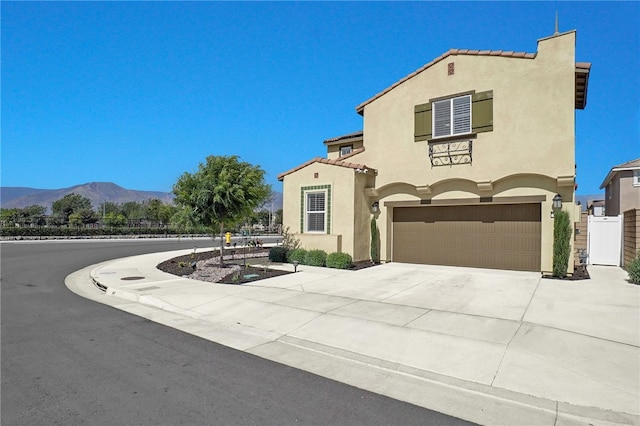 1768 Camellia Ln, Redlands, CA 92374 - mediterranean / spanish-style home with stucco siding, an attached garage, a mountain view, driveway, and a tiled roof