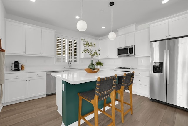 1768 Camellia Ln, Redlands, CA 92374 - kitchen featuring stainless steel appliances, white cabinets, wood finished floors, recessed lighting, and light countertops