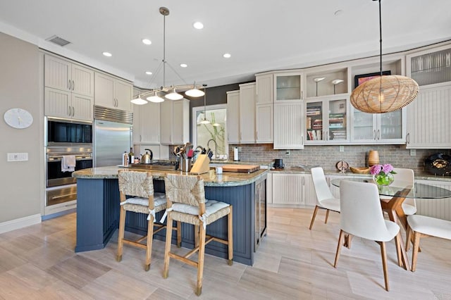 834 S Cedros, Solana Beach, CA 92075 - kitchen with built in appliances, a warming drawer, decorative backsplash, recessed lighting, and glass insert cabinets