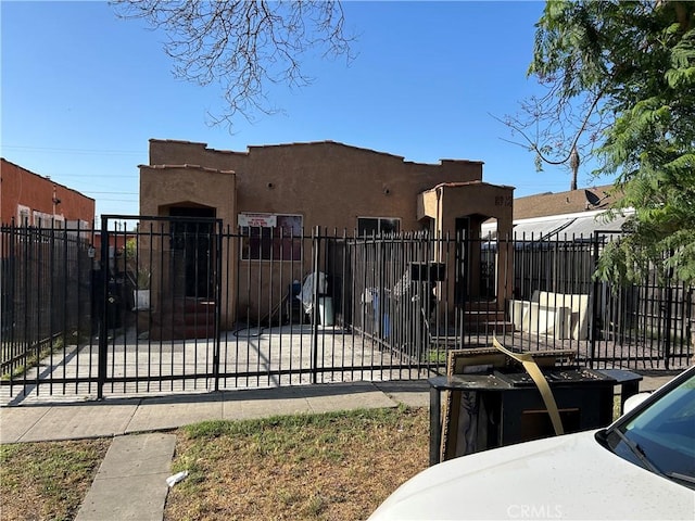 915 E 80th St, Los Angeles, CA 90001 - view of front of property with a fenced front yard, stucco siding, and a gate