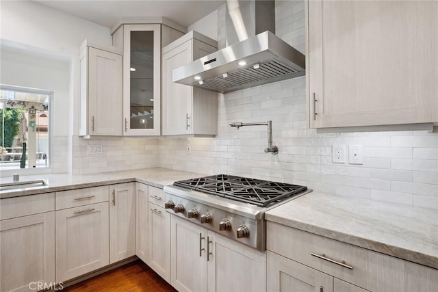22501 Marilla St, Chatsworth, CA 91311 - kitchen with wall chimney exhaust hood, stainless steel gas stovetop, light stone countertops, glass insert cabinets, and tasteful backsplash