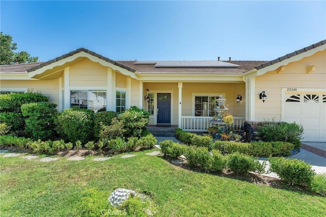 22501 Marilla St, Chatsworth, CA 91311 - view of front of home featuring a porch, a front lawn, roof mounted solar panels, and a garage