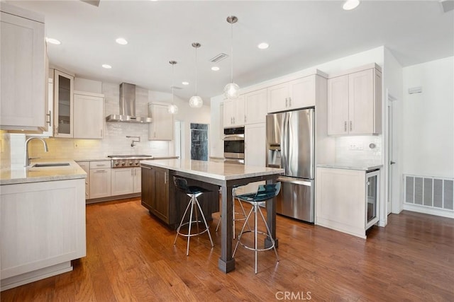 22501 Marilla St, Chatsworth, CA 91311 - kitchen with appliances with stainless steel finishes, wall chimney range hood, backsplash, a center island, and dark wood-type flooring