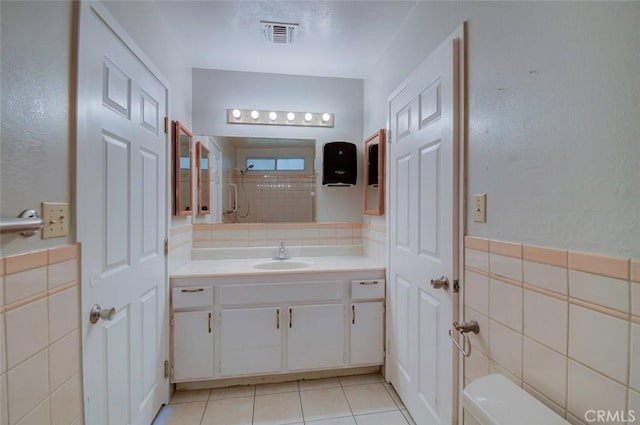 12911 Browning Ave, North Tustin, CA 92705 - full bath with tile walls, vanity, tile patterned floors, and a wainscoted wall