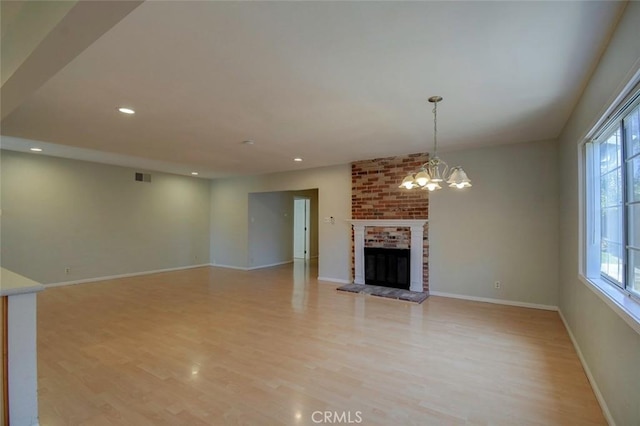 12911 Browning Ave, North Tustin, CA 92705 - unfurnished living room featuring light wood-style floors, recessed lighting, a brick fireplace, and a chandelier