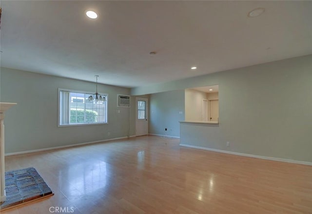 12911 Browning Ave, North Tustin, CA 92705 - unfurnished living room with a chandelier, light wood finished floors, recessed lighting, and a wall mounted air conditioner