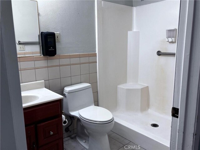 12911 Browning Ave, North Tustin, CA 92705 - full bath with vanity, a walk in shower, tile walls, tile patterned flooring, and wainscoting